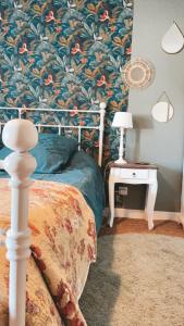 a bedroom with a bed with a floral wallpaper at Le moulin de l Epine in Taintrux