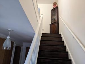 a staircase in a house with a clock on the wall at TravelStop #Ealing in London