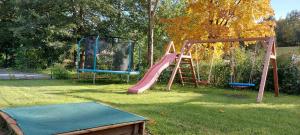 a playground with two swings and a slide at Chalupa Bílá stopa - celá chalupa pro jednu partu in Stará Ves