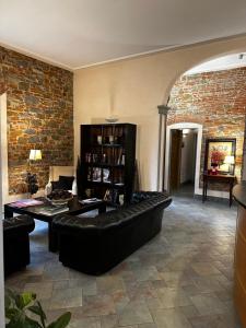 un soggiorno con divano nero e muro di mattoni di Hotel Villa Betania a Firenze
