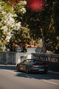 un coche está conduciendo por una calle con un cartel en Hotel Villa Maria Au Lac - Estella Hotels Italia, en Toscolano Maderno