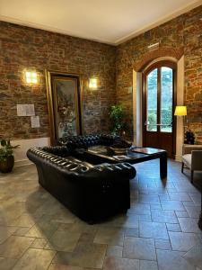 a living room with a black leather couch and a table at Hotel Villa Betania in Florence
