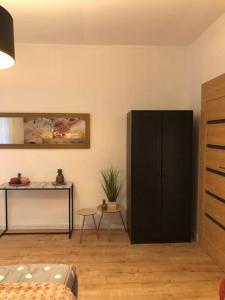 a living room with a black cabinet and a table at Luma Exclusive in Osijek