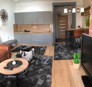 a living room with a table and a kitchen at Luma Exclusive in Osijek