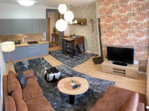 a living room with a couch and a television at Luma Exclusive in Osijek