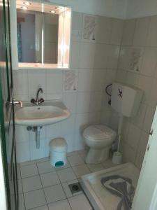 a small bathroom with a sink and a toilet at Sun Helios Garden Aparthotel in Limenas