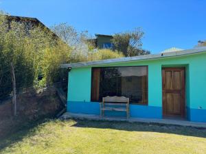 une maison bleue et verte avec une fenêtre dans l'établissement Lidia's Mountain View Vacation Homes, à Monteverde Costa Rica