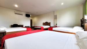 a room with three beds with red and white sheets at Hotel Beijing Caucasia in Caucasia +30 photos