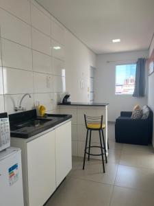 cocina con encimera y taburete en una habitación en Pousada Suites Enseada Guaruja en Guarujá