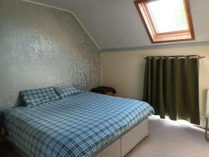 um quarto com uma cama com um cobertor xadrez azul em Abiento em Wexford