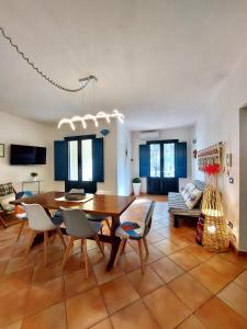 a living room with a table and chairs and a couch at Jennas-Maestrale Apartment in Àrbatax +26 photos