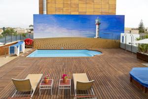 una terraza con piscina y un faro en un edificio en Hotel Rull en Deltebre