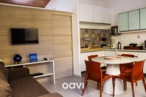 cocina y sala de estar con mesa y sillas. en Qavi - Apartamento no Centro de Pipa #Solar216, en Pipa