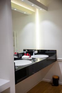 a bathroom with two sinks and a large mirror at Hotel de Maître de Vaughan in Brussels