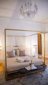 a bedroom with a canopy bed with a table at Hotel de Maître de Vaughan in Brussels