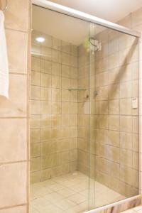 una doccia con porta in vetro in bagno di Hotel Costa do Atlantico a Natal