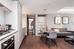 eine Küche und ein Wohnzimmer mit einem Tisch und einem Sofa in der Unterkunft New Build-Air Con-2 Bedroom-Two Bathrooms Apt 4 in London
