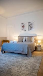 ein Schlafzimmer mit einem großen Bett mit einer blauen Decke in der Unterkunft Hotel de Maître de Vaughan in Brüssel