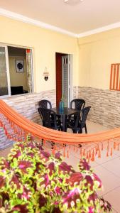 een patio met een tafel en stoelen en een plant bij House Maraca in Ipojuca