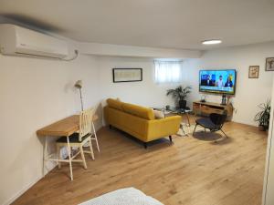 ein Wohnzimmer mit einem gelben Sofa und einem Tisch in der Unterkunft המקום של מוש in Pardes H̱anna