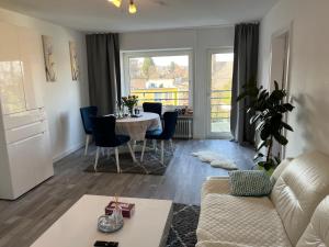 a living room with a table and a couch at Apartment Meditari Bonn-Muffendorf in Bonn