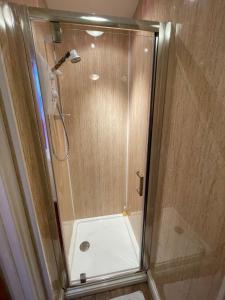 a shower with a glass door in a bathroom at Môr Wyn Guest House in Barmouth