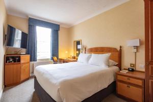a hotel room with a large bed and a television at Avisford Park Hotel in Arundel +98 photos