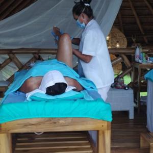 una persona sdraiata su un letto con un'infermiera di Villeta Casa de Campo caracoli spa a Villeta