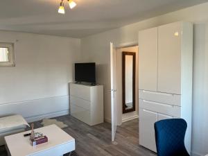 ein kleines Wohnzimmer mit einem Bett und einem TV in der Unterkunft Apartment Meditari Bonn-Muffendorf in Bonn