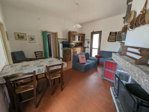 una cucina e un soggiorno con tavolo e sedie di (P3347) Cottage familiare Sant'Agostino ad Abbasanta