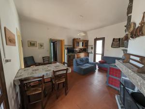 een keuken en een woonkamer met een tafel en stoelen bij (P3347) Cottage familiare Sant'Agostino in Abbasanta