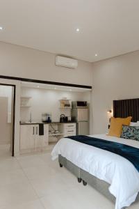 a bedroom with a large bed and a kitchen at Marjaniek Wedding Venue & Guest House in Rietfontein