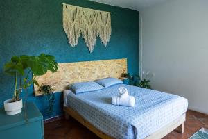 1 dormitorio con 1 cama con pared azul en Colibrí Turquesa, en Tepoztlán