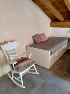 a bed and a chair in a room at Maison Cascina Amélie in Abbadia Lariana