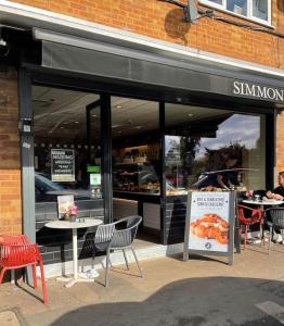 a restaurant with tables and chairs in front of a building at Self contained studio with own front door in Nazeing