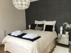 a bedroom with a white bed with a chandelier at Self contained studio with own front door in Nazeing