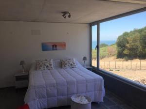 1 dormitorio con cama y ventana grande en Modern apartment with the best view., en Punta del Este