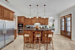 a kitchen with wooden cabinets and a island with bar stools at Luxury home with outdoor patio and game room in Memphis