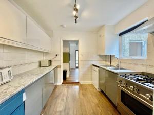 uma cozinha com armários brancos e um forno com placa de fogão em Tranquil Rentals - Large 4 BDR Home, 3 Bathrooms, Free Parking, Monthly Discounts em Oxford