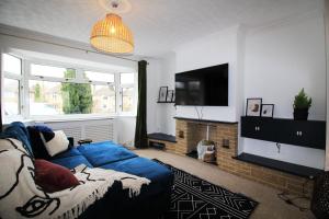uma sala de estar com um sofá azul e uma televisão em Tranquil Rentals - Large 4 BDR Home, 3 Bathrooms, Free Parking, Monthly Discounts em Oxford
