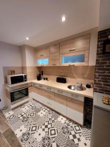 eine Küche mit einer Spüle und einer Mikrowelle in der Unterkunft HORIZON SPA in Samer