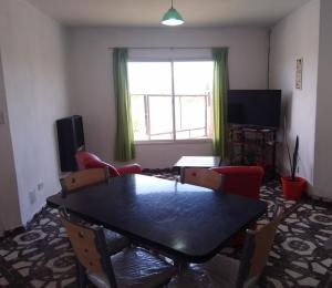 a living room with a table and chairs and a window at Casa Los Robles in Trevelín