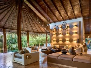 sala de estar de planta abierta con sofá y mesa en Cala Luna Boutique Hotel & Villas, en Tamarindo