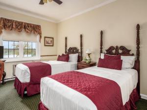 a bedroom with two beds with red and white sheets at Lafayette Hotel Marietta in Marietta