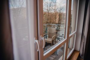 een raam met uitzicht op een balkon met een stoel bij JBHotels Apartament Premium Plus in Szczecin