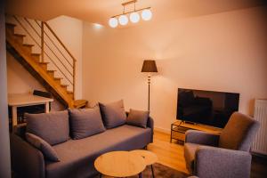 een woonkamer met een bank en een flatscreen-tv bij JBHotels Apartament Premium Plus in Szczecin
