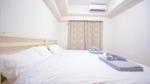 東京的住宿－TOKYO EXPERT SHINJUKU，一间卧室配有两张带毛巾的床