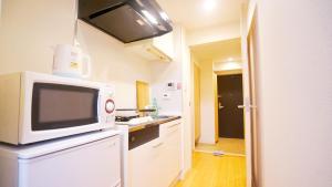 東京的住宿－TOKYO EXPERT SHINJUKU，厨房配有冰箱上方的微波炉