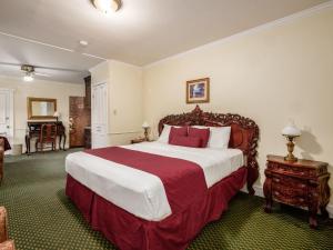 a bedroom with a large bed with red and white pillows at Lafayette Hotel Marietta in Marietta