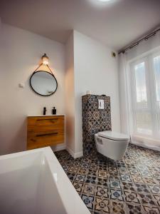 a bathroom with a tub and a toilet and a sink at JBHotels Apartament Premium Plus in Szczecin